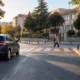 Okul çevresindeki yaya geçidinde otomobil ve karşıya geçen yaya, temsili görsel